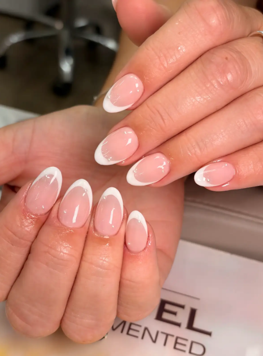 Classic French ombre almond nails with glossy milky pink base and white tips