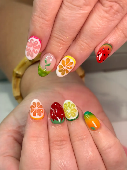 Summer fruit nail art with hand-painted citrus slices, strawberries and watermelon on almond nails