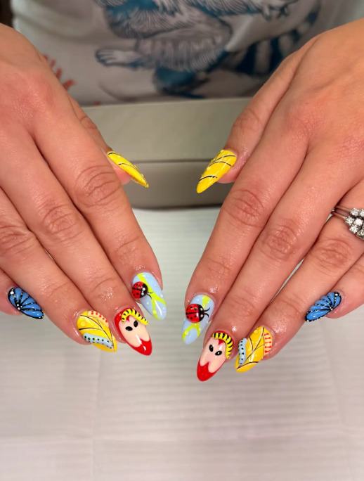 Playful cartoon nail art with 3D ladybugs, butterfly wings and hand-painted yellow leaves