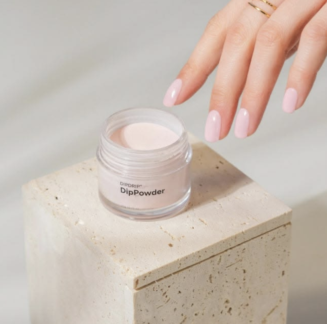 Soft pink nails above an open jar of dipping powder