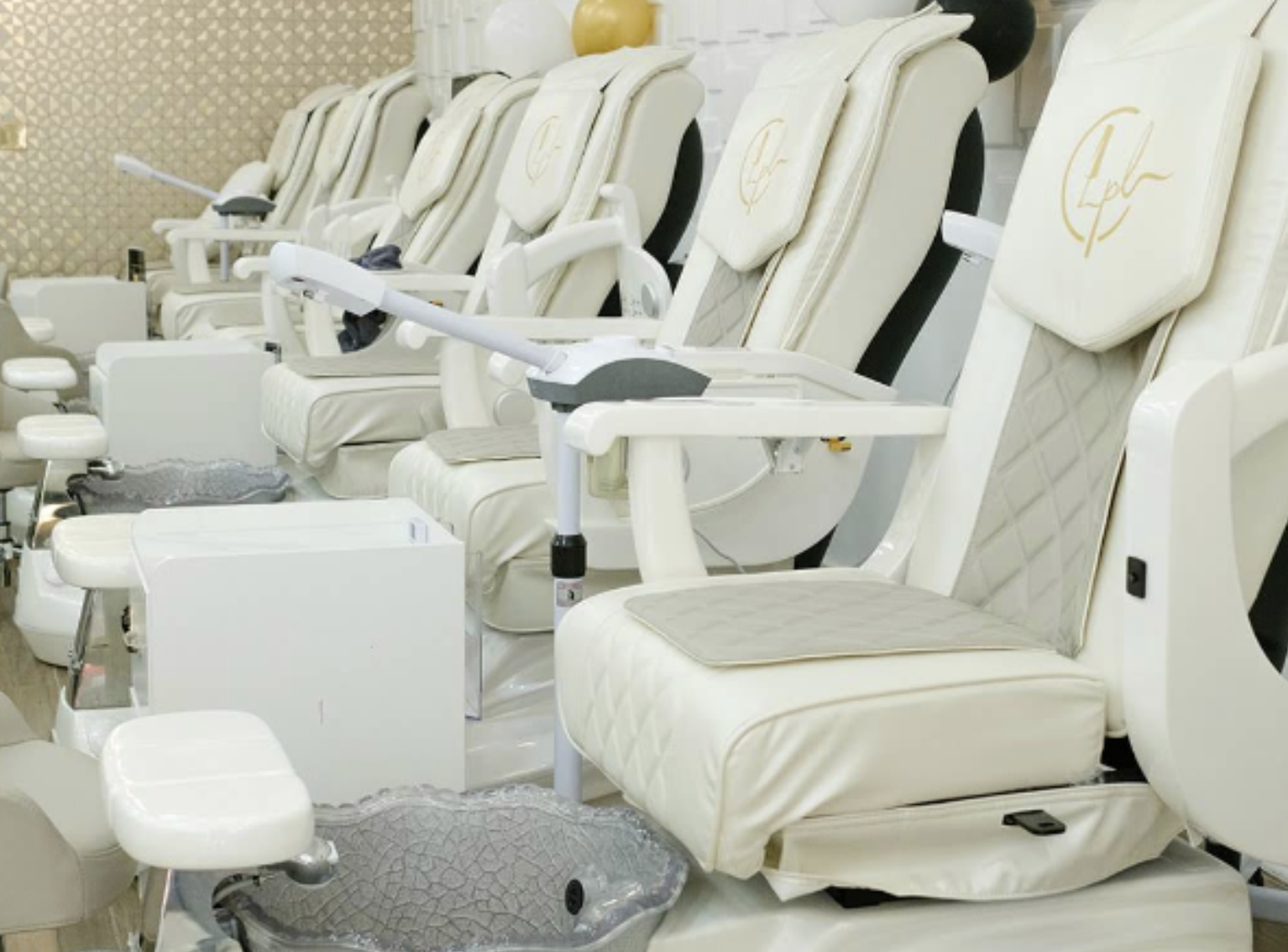 Row of cream and gold pedicure spa chairs at Constance Polish Lounge